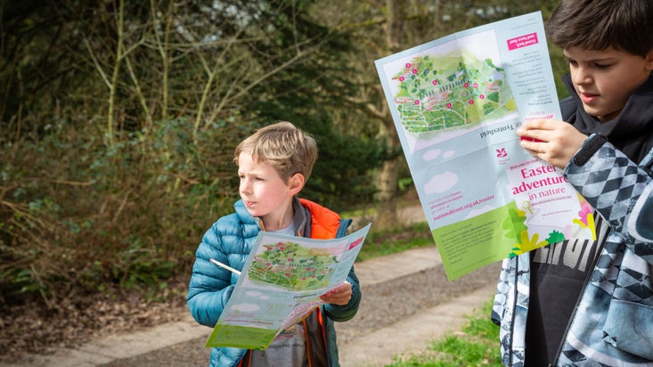 Two young boys with maps on the Easter trail at Tyntesfield, Somerset